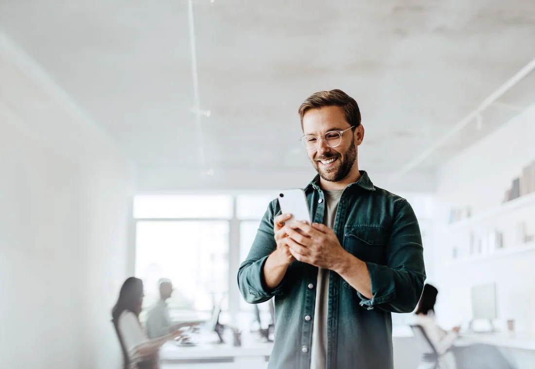 Un professionnel consulte son smartphone dans ses locaux